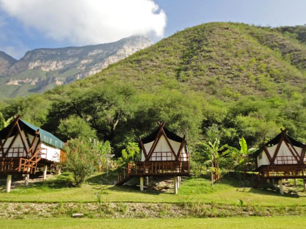 Glamping en Querétaro Toma abierta de tres cabañas al pie de una montaña