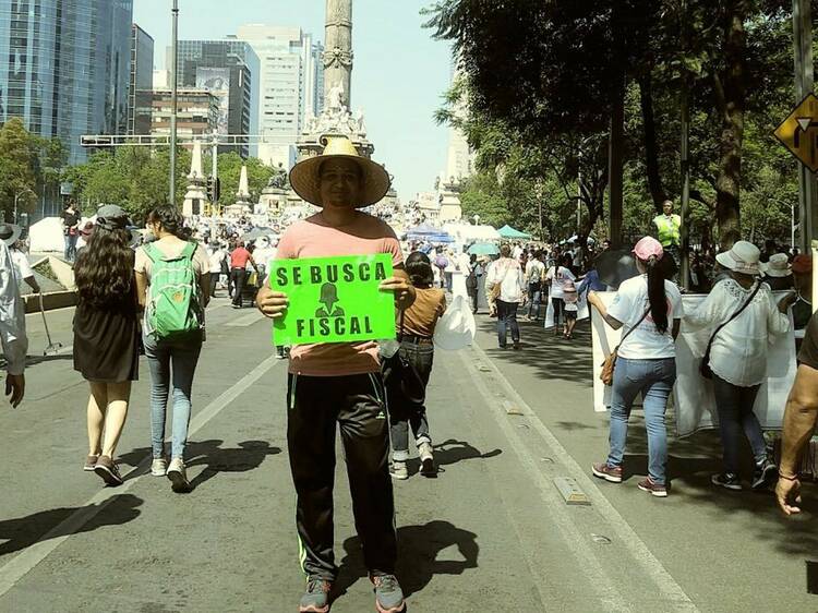 Foto de cuerpo entero de un hombre en una manifestación sobre Reforma