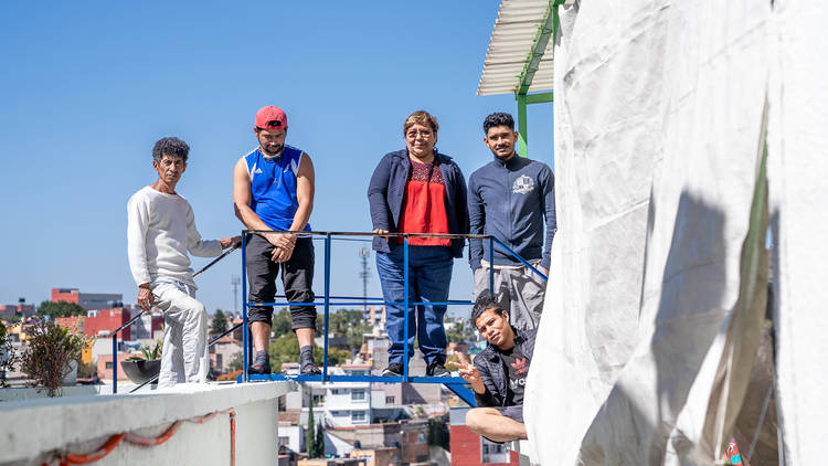 Retrato de cinco personas sobre unas escaleras de herrería