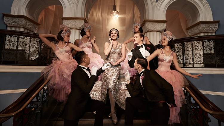 The Merry Widow cast in Deco-inspired costumes, in opulent surrounds