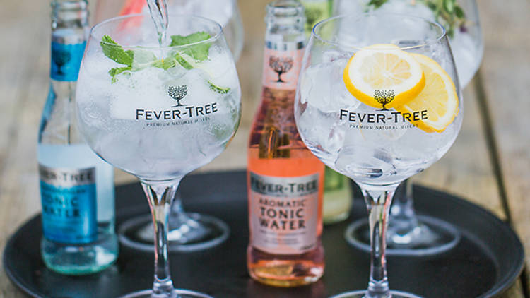 Gin and tonics being poured on a tray