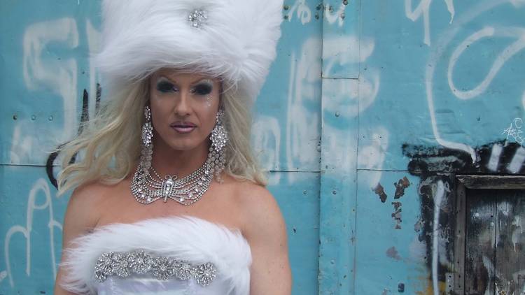 Drag queen Amelia Airhead poses in fluffy white hat and matching dress