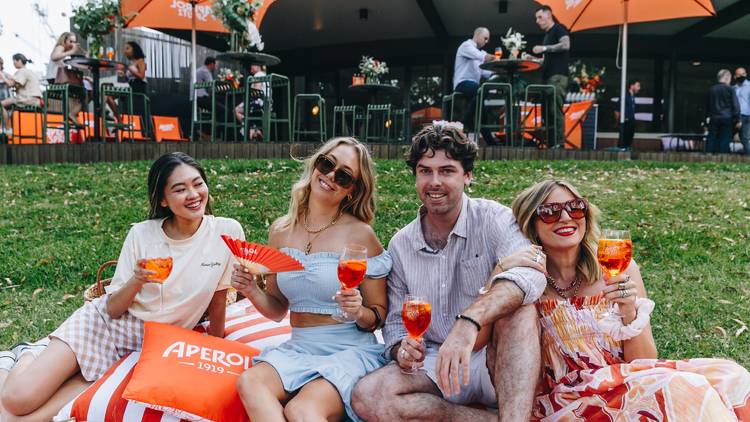 Four people drinking Aperol