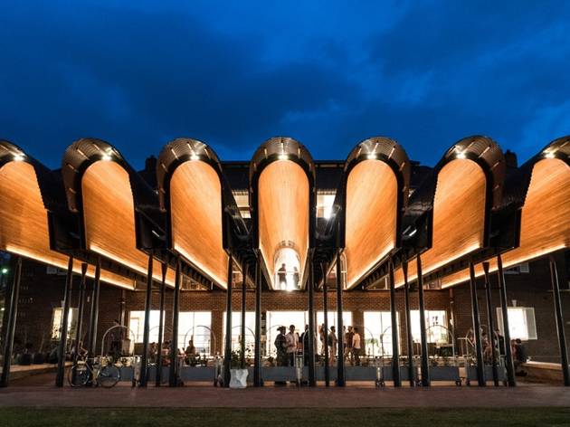 Joynton Avenue Creative Centre An exterior shot of the Joynton Avenue Creative Centre at dusk, with it's wooden arches aglow