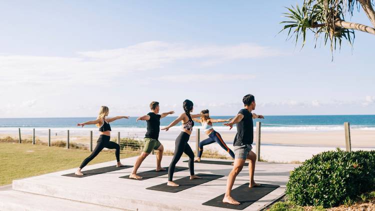 People doing yoga watching the beach