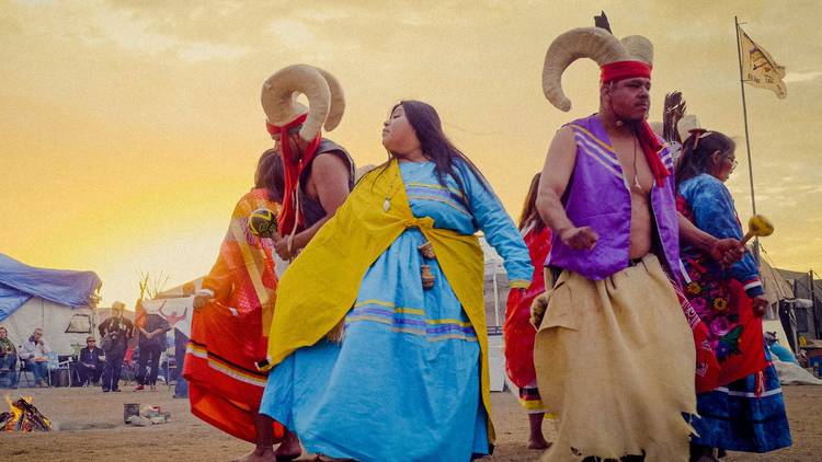 Indigenous dancers in bright colours appear in activist film Invisible Hand