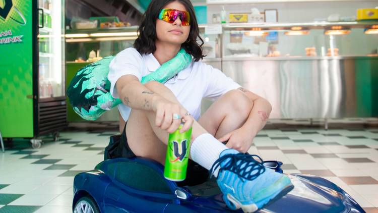 Artist Amy Toma in costume riding a miniature blue car