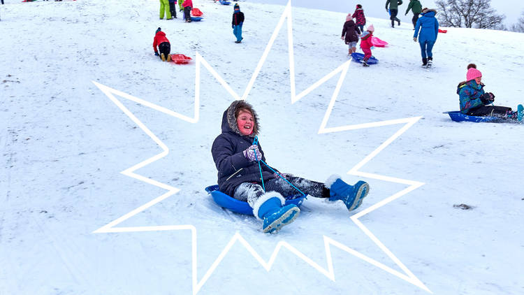 children sledging on a snowy field