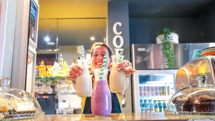 Melbourne Central cafe with waitress smiling and holding cold pressed juices