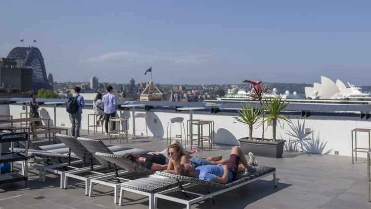 Guests enjoying the roof top with views of Sydney Harbour on a sunny day