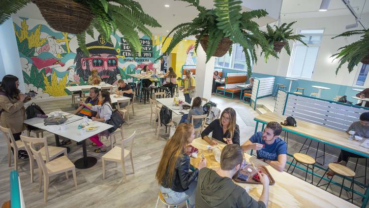 Guests eating in the Sydney Central dining area with colourful interiors and plants 