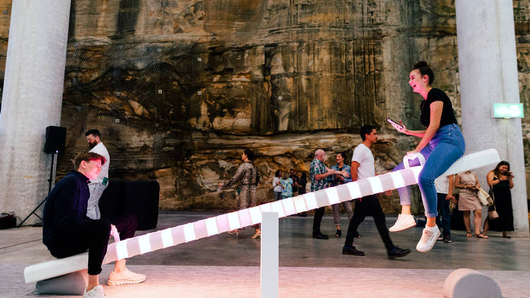 Two people on a light-up see saw in the Barangaroo Cutaway.