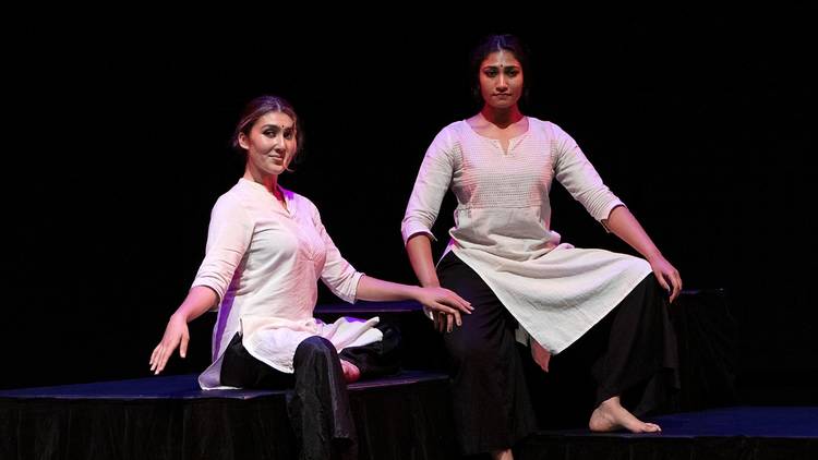 Two women pose on stage as part of The Flowering Tree
