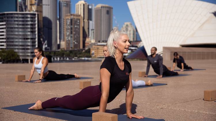 People doing yoga in front of the Sydney Opera House