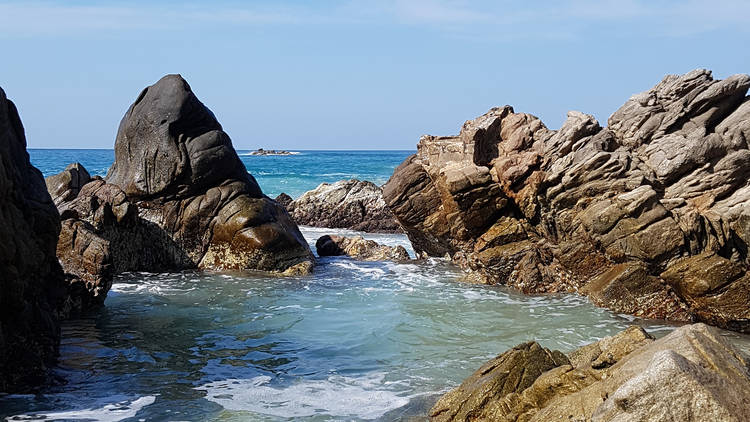 Playa de Puerto Escondido con rocas en el mar