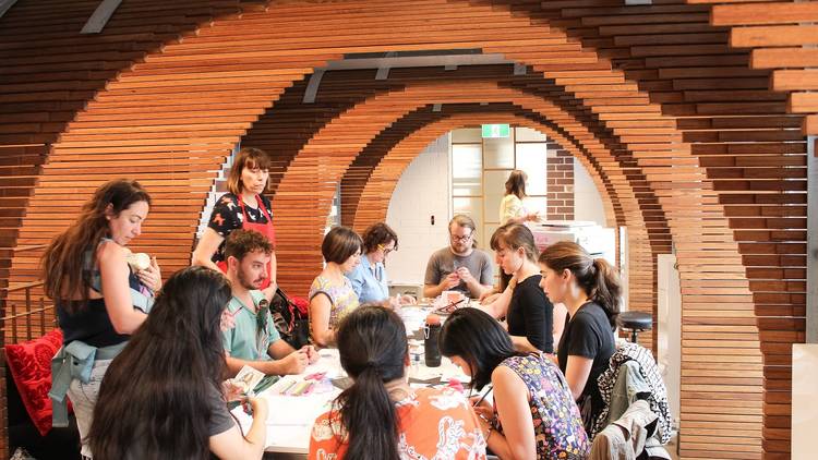 People sit at table doing workshop in wood panelled room