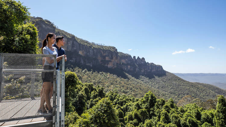 A couple look out over the Jamison Valley from the Katoomba Falls lookout