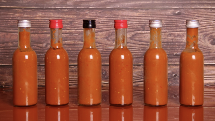 Chilli sauces lined up in a row on a table