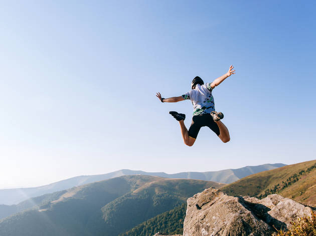 Base jumping Man jumps from cliff in mountains aka base jumping