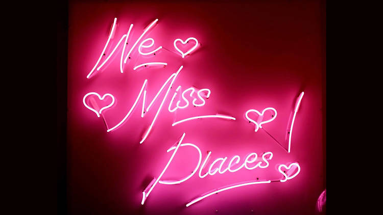 Neon sign that says We Miss Places