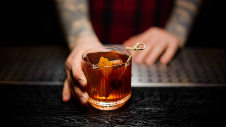 Bartender serving an Old Fashioned