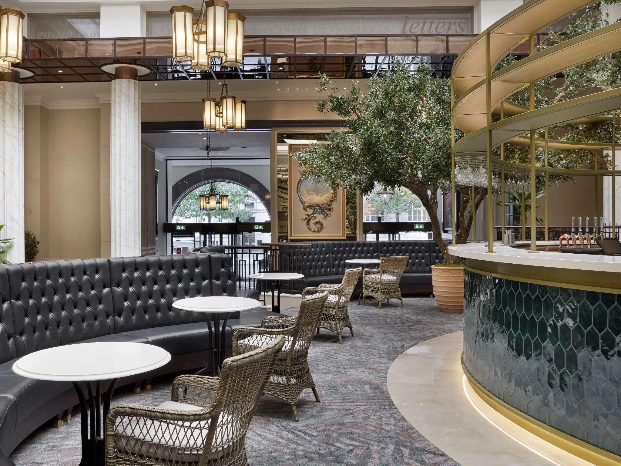 interior hotel lobby with green tiled bar and seating area