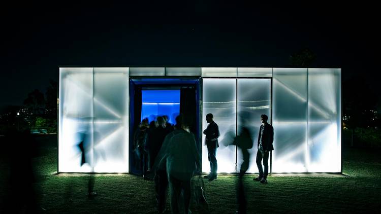 People mill around glowing audio-visual pop-up venue Blak Box