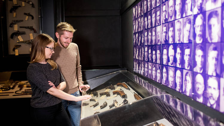 A man and woman looking at a display of confiscated weapons at the Justice and Police Museum