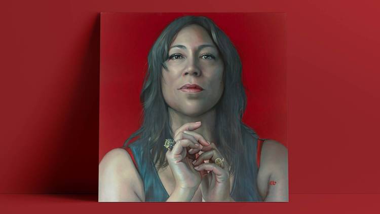 A portrait of singer Kate Ceberano on a dramatic blood-red backdrop 