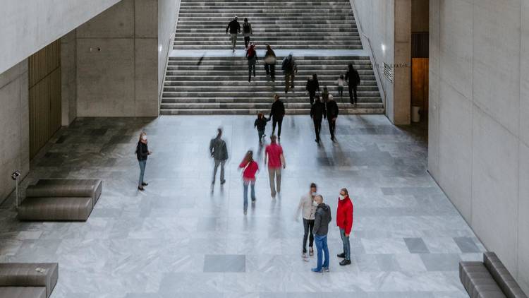 People walk through a busy building in Zurich.