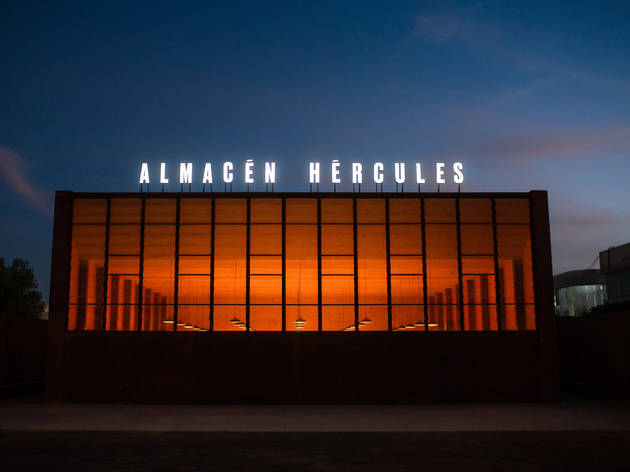 Cervecería Hércules en Querétaro Fachada de vidrio con luz roja al fondo
