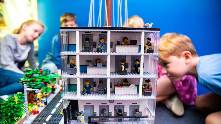 Kids peer into a Lego sculpture