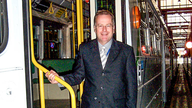 Colin Tyrus, voice of Melbourne trams, standing in the stairwell of an old style melbourne tram at a depot