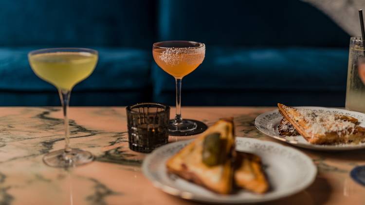 Two drinks in front of plates of jaffles