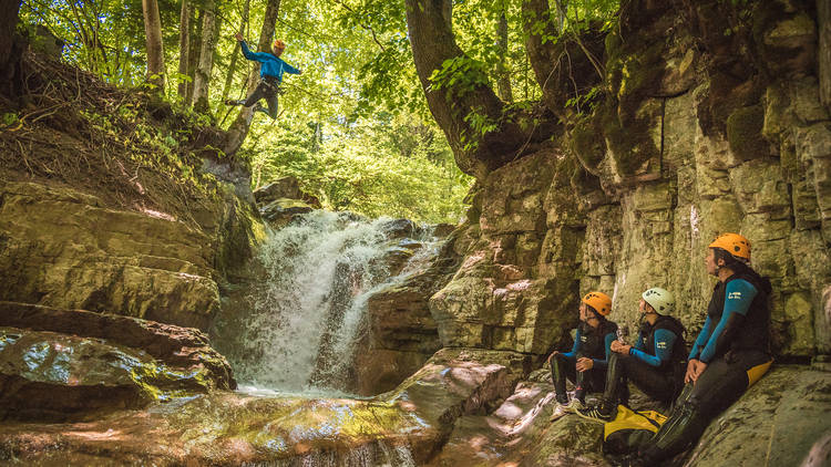 Someone leaping into water as part of a canyoning activity.