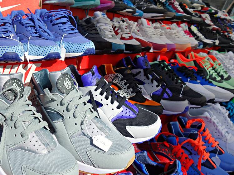 Sneakers of different colours on racks