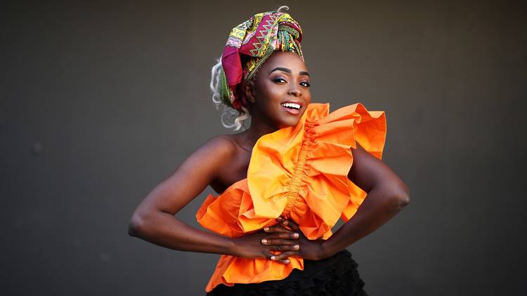 Actor, singer and model Suzan Mutesi wears a ruffled orange dress