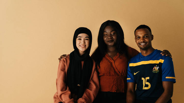 Three people sit infront of a yellow background