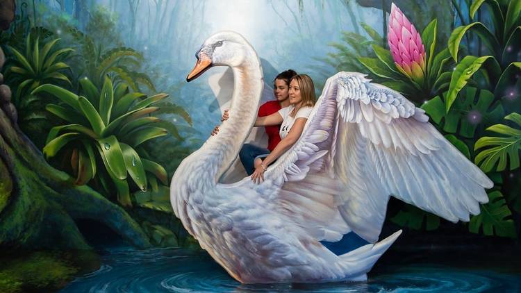 Two women riding on the back of a giant swan