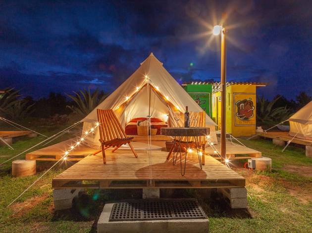Glamping Octli en el Santuario de las Luciérnagas Frente de tienda de campaña tipo safari con serie de focos durante la noche