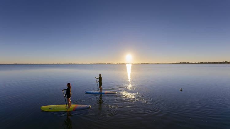 Two people paddleboarding on Lake Boga