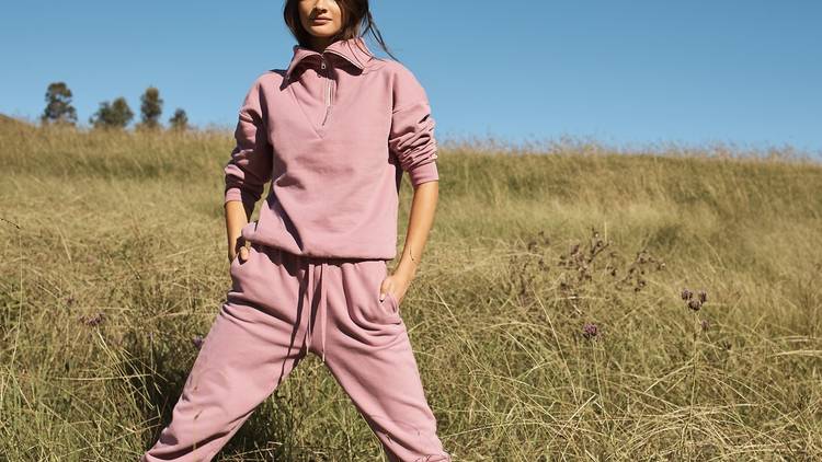 A fashion model in a pink outfit in the long grass