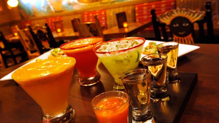 Three margaritas and a tequila flight on a table