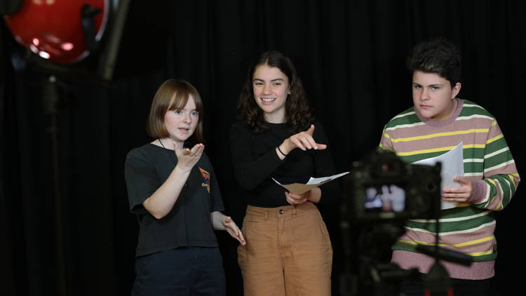 Three young people gesturing in front of a camera in an ATYP drama class