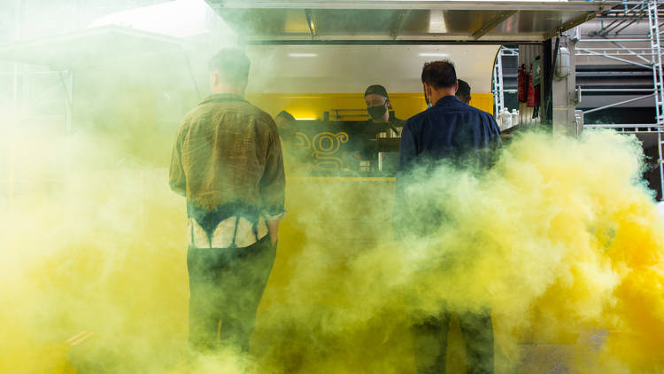 A yellow cloud and two people by a food truck