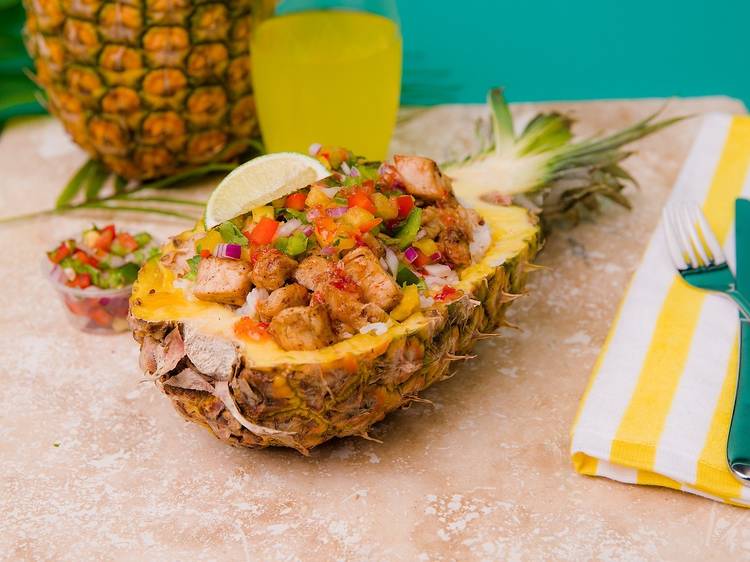 Meat and vegetables laid inside a hollowed out pineapple