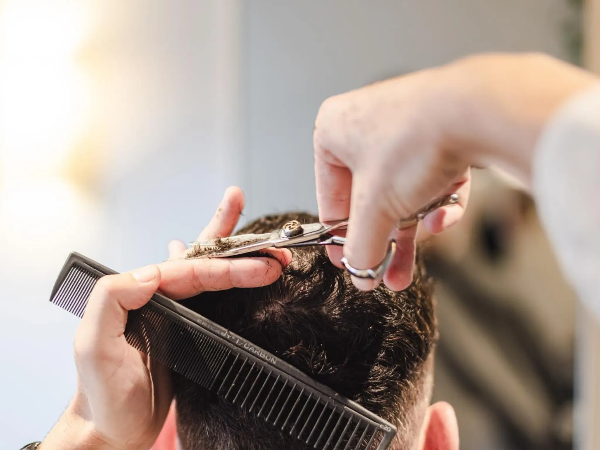 Rear view of person's head as they get a haircut.