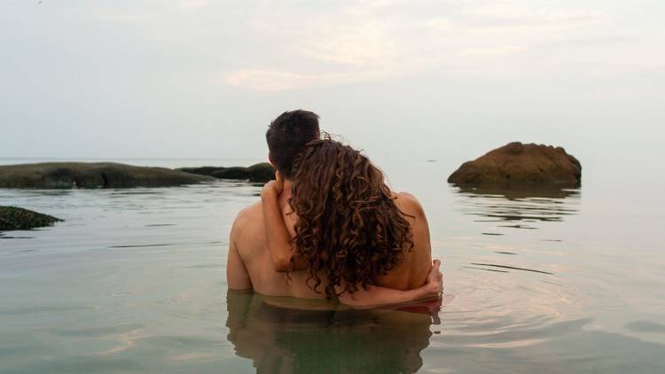 A man and a woman holding each other in chest-deep water