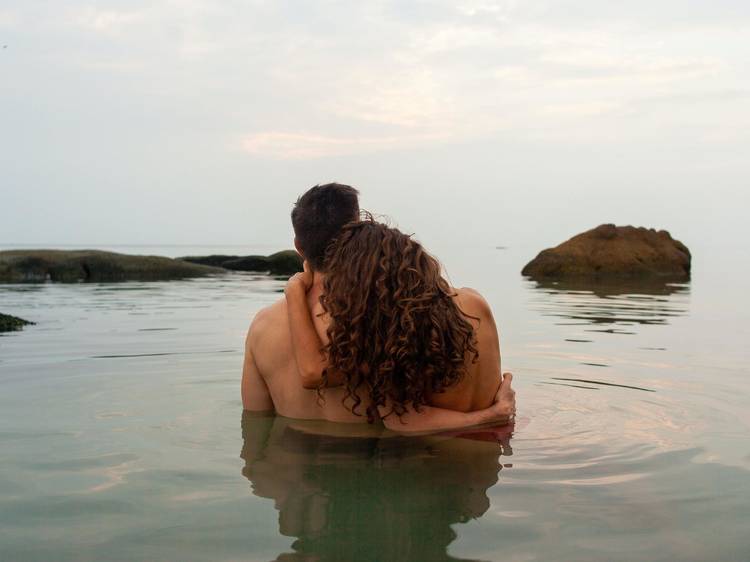 A man and a woman holding each other in chest-deep water