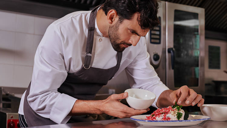 Chef de perfil preparando un chile en nogada